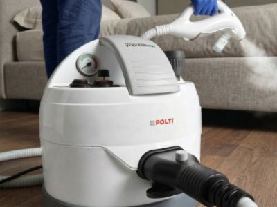 Polti Cimex Eradicator steamer being used for bed bug treatment on sofa and upholstered furniture